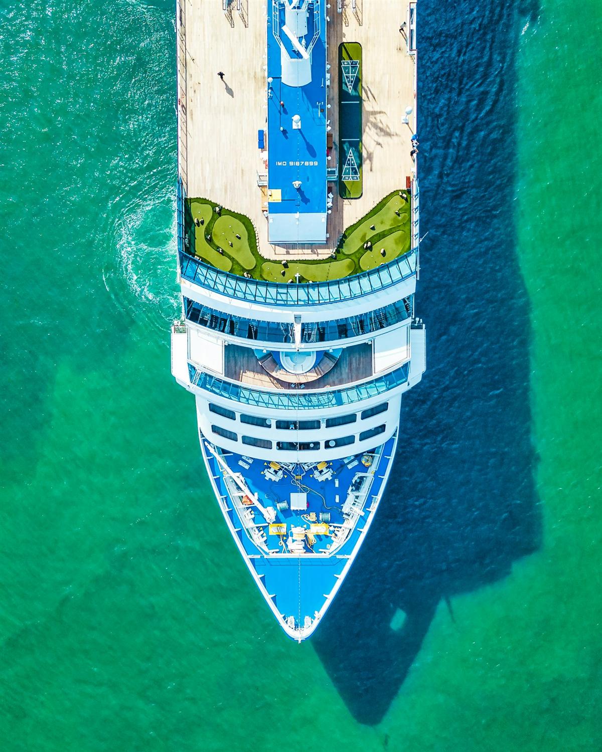 Luchtfoto van een groot cruiseschip met zwembaden op turquoise water