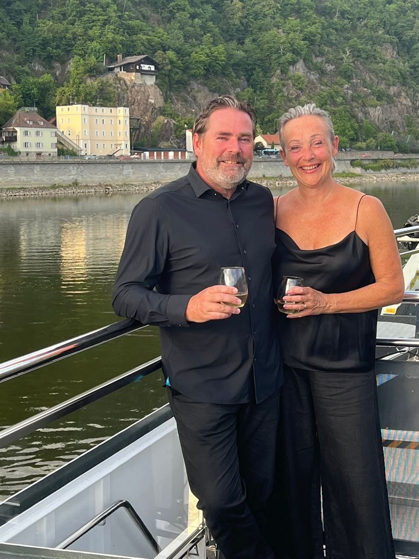 Yves met een glas wijn aan dek van een riviercruiseschip